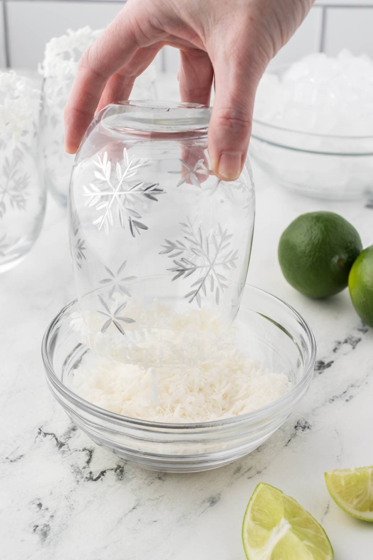 A glass being rimmed with shredded coconut.