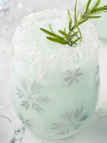 A frothy blended cocktail in a festive holiday glass.