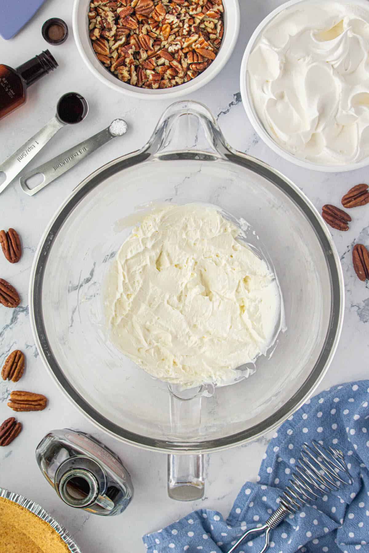 Cream cheese in a mixixng bowl that has been whipped until creamy.