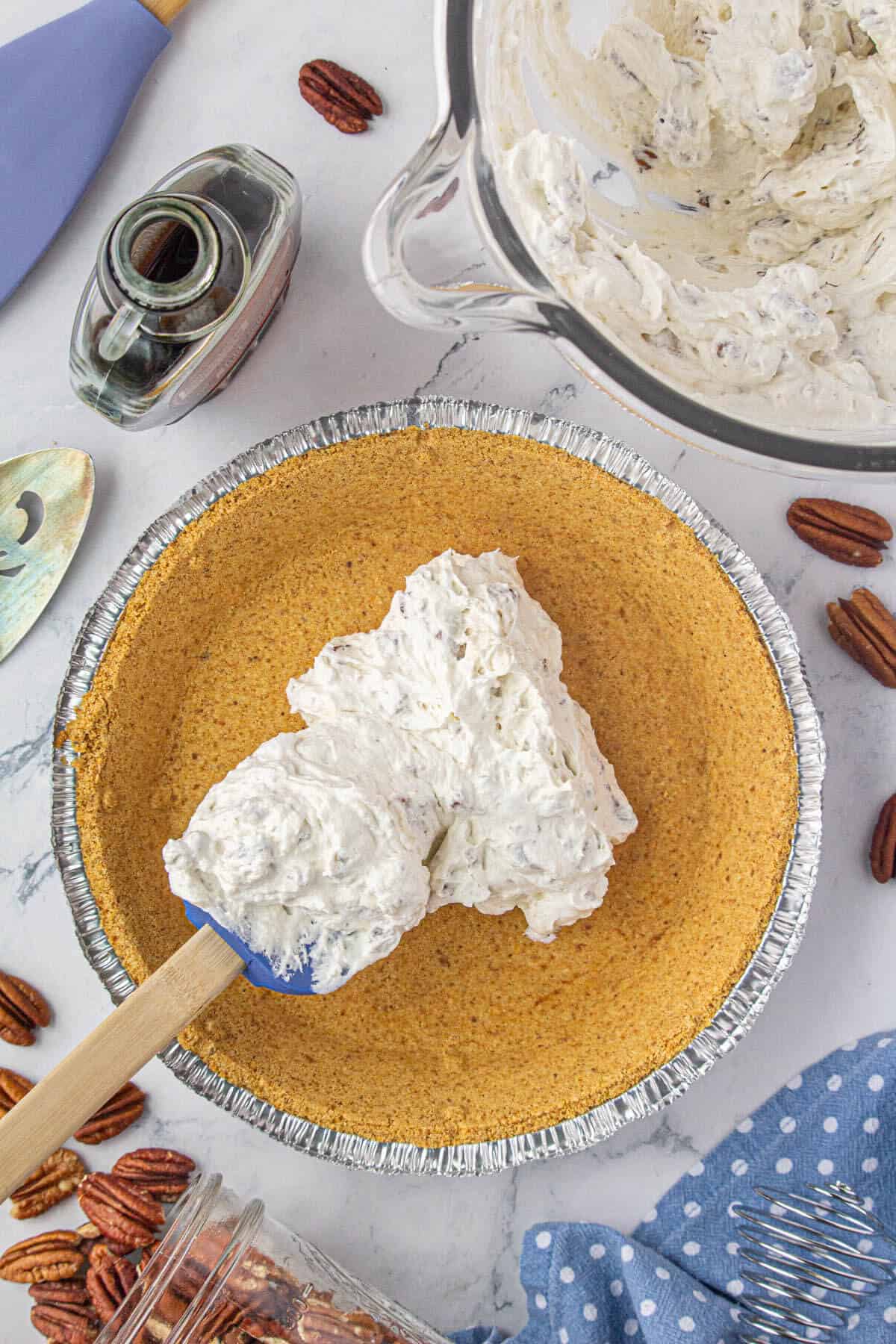 Cream cheese pie mixture spooned into a graham cracker crust.