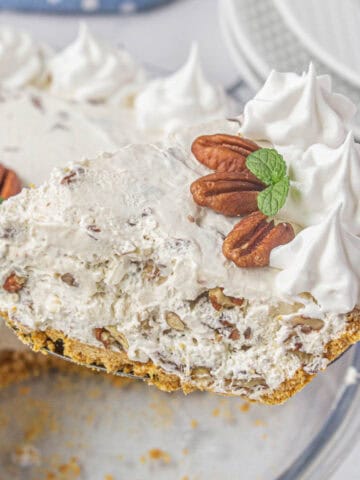 A slice of pecan cream pie on a serving spatula.