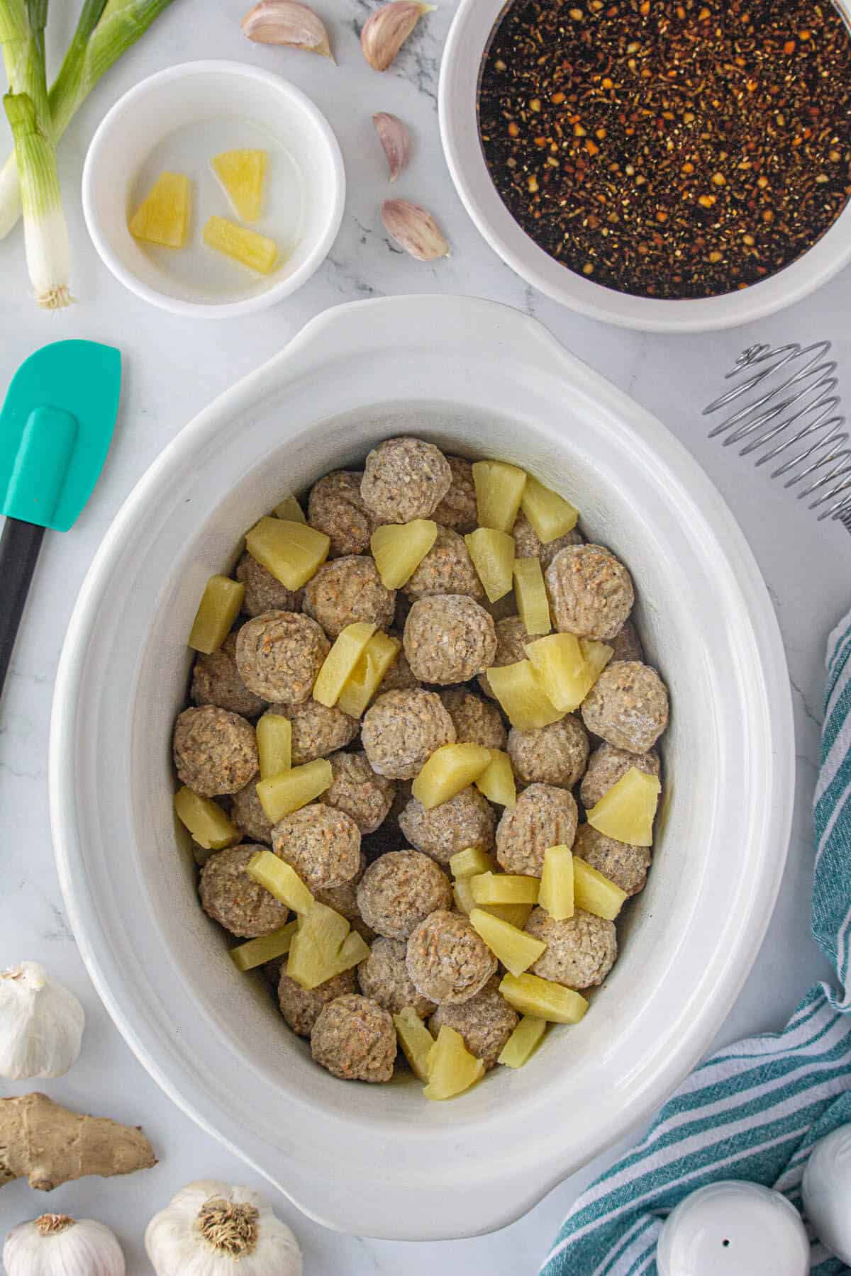 Meatballs and pineapple chunks in a crockpot.