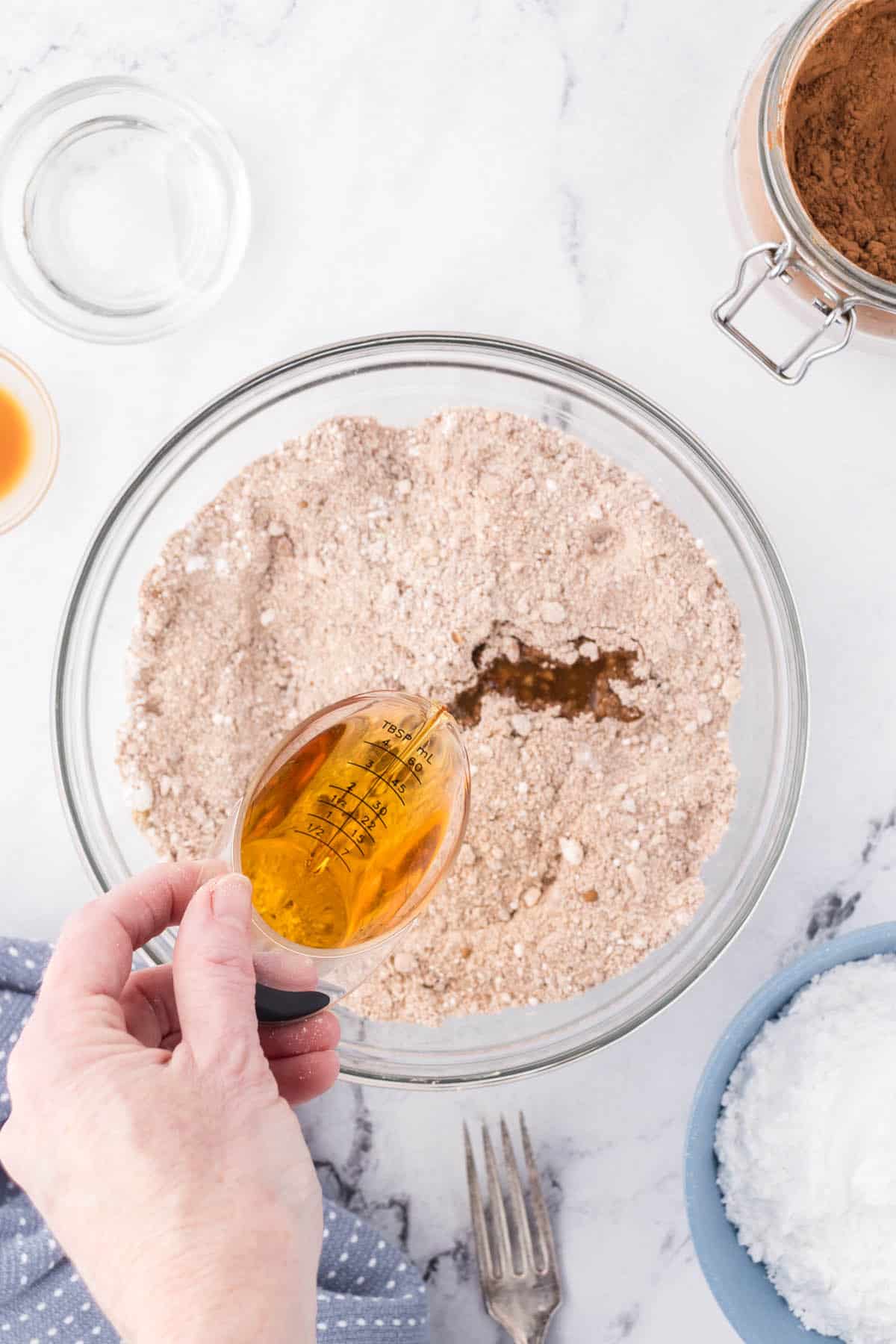 Bouton being added to the cookie crumb mixture in a large mixing bowl.