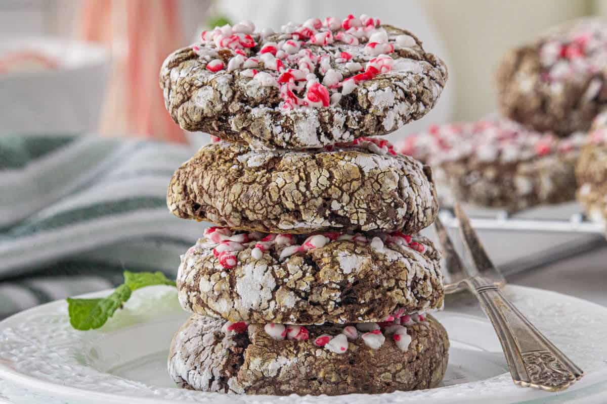 A stack of four chocolate cookies on a plate.