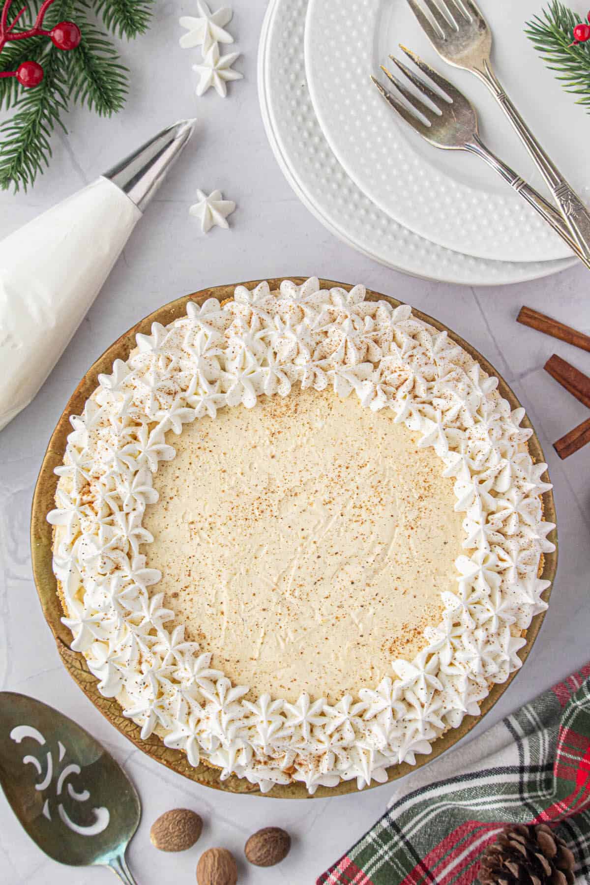 The no bake eggnog pie has been decorated with whip cream stars and dusted wtih cinnamon and nutmeg.