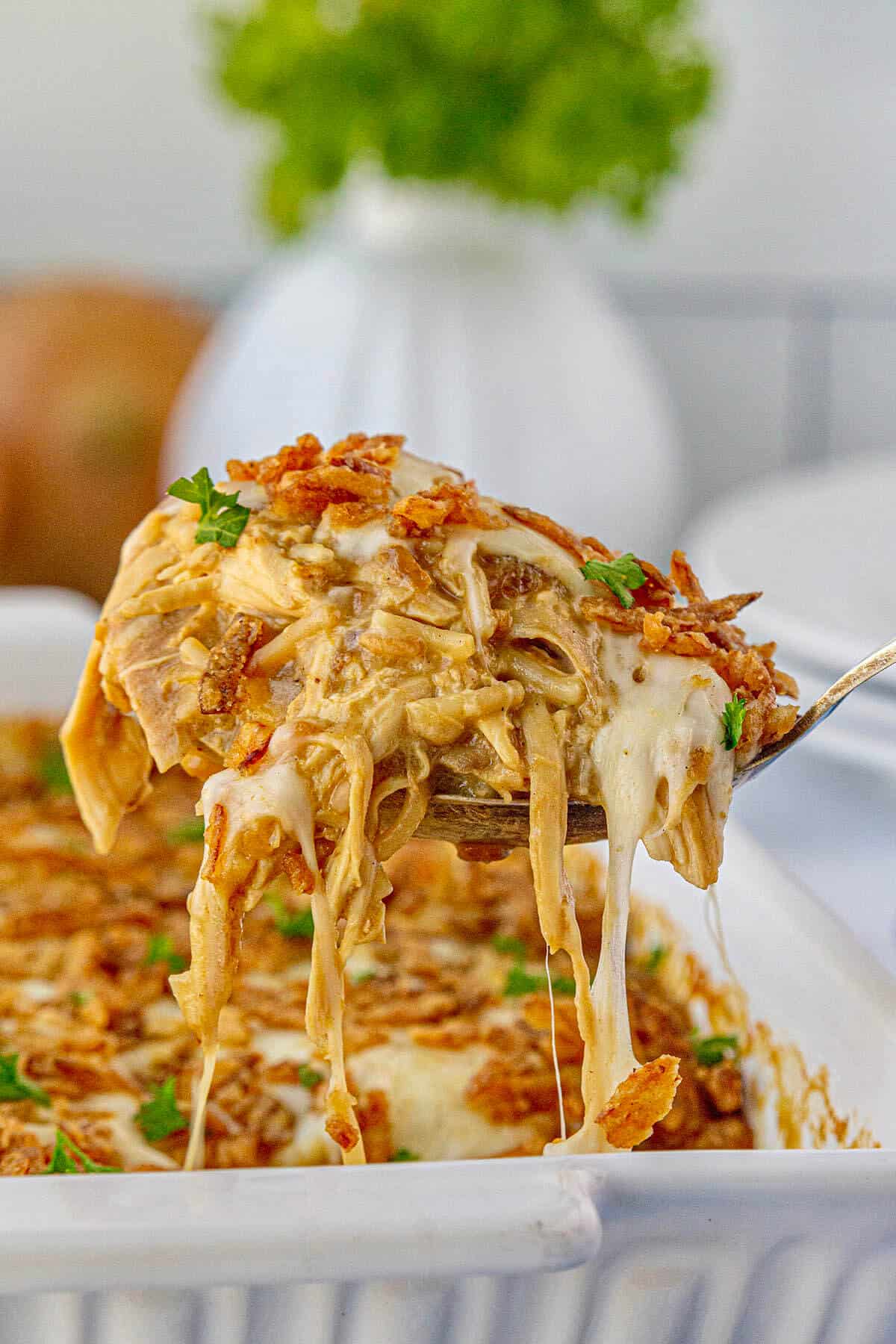 French Onion Chicken and Rice in a casserole dish with a big serving spoon taking a scoop.