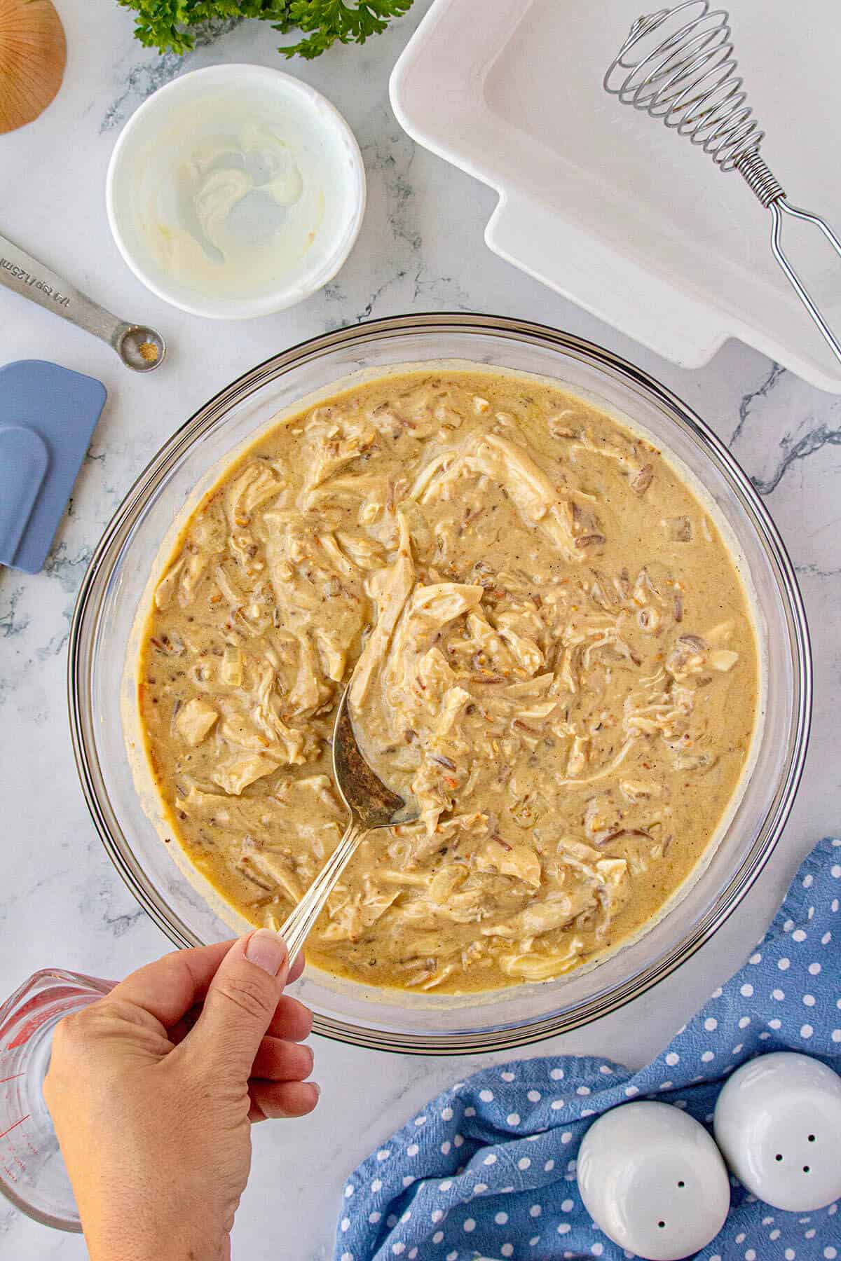 Combined chicken mixture in a large bowl with a spoon to stir.