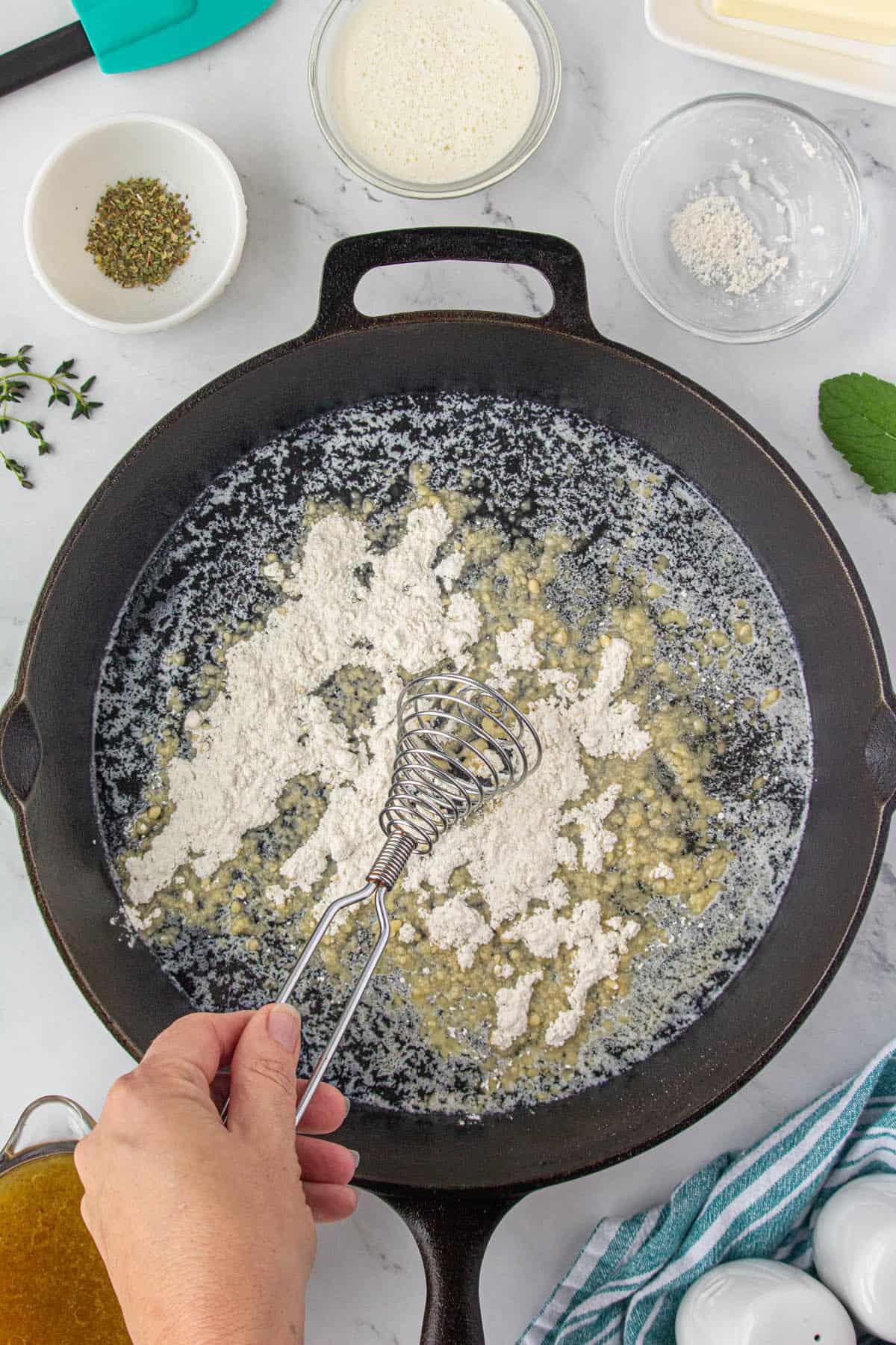 Whising flour a skillet with melted butter.