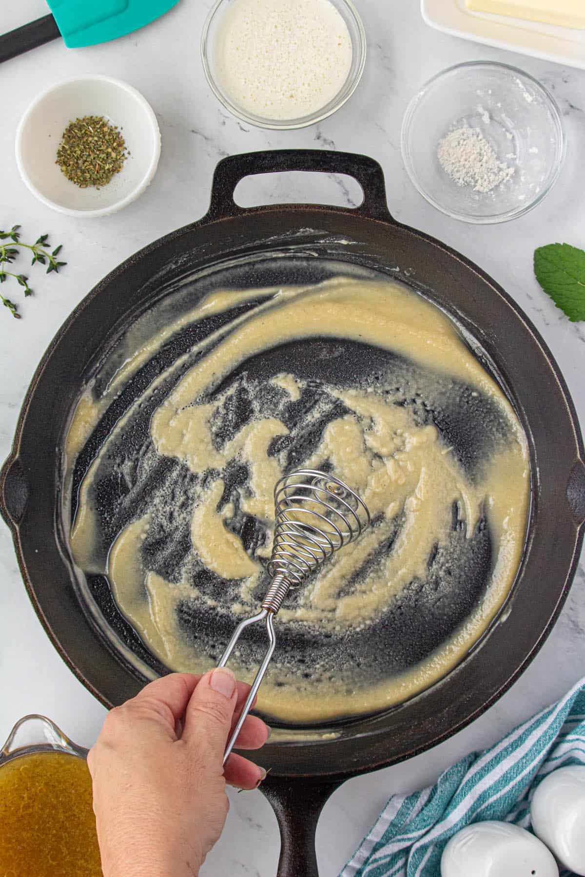 A rich golden roux whisked in a skillet.