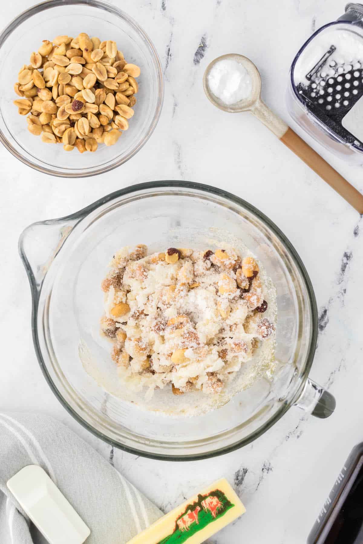 Peanuts, karo syrup and sugar stirred together in a bowl.