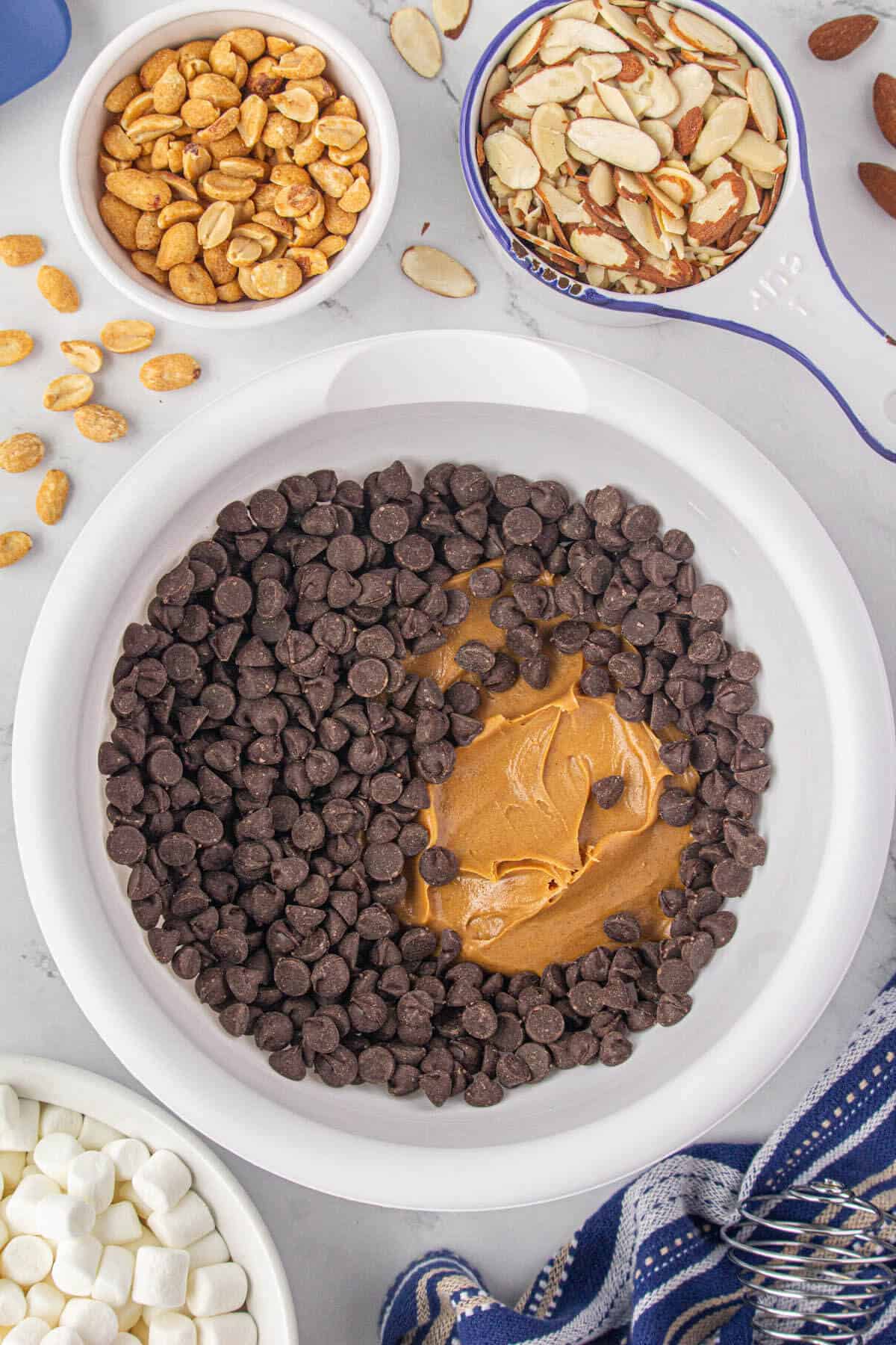 Dark chocolate chips in bowl with creamy peanut butter, ready to melt in the microwave.