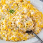 Creamed corn in a large bowl with a serving spoon.