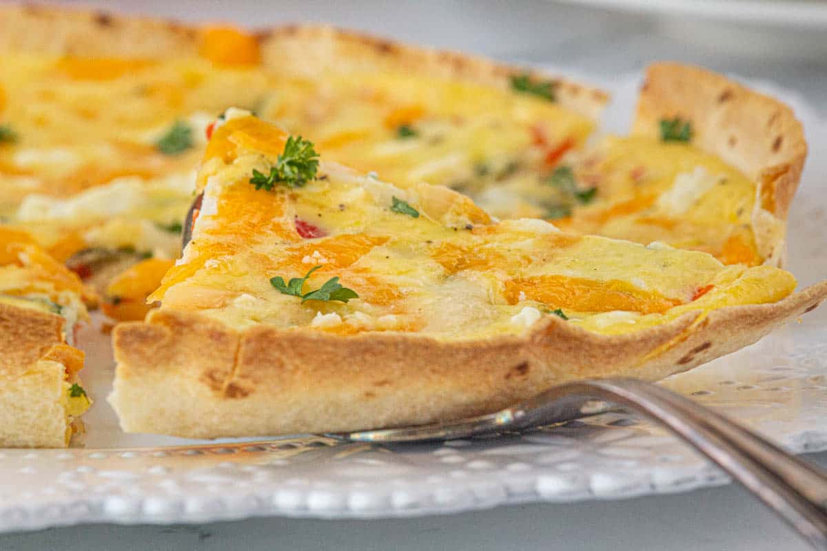 Sliced wedges of tortilla egg quiche on a platter ready to serve.