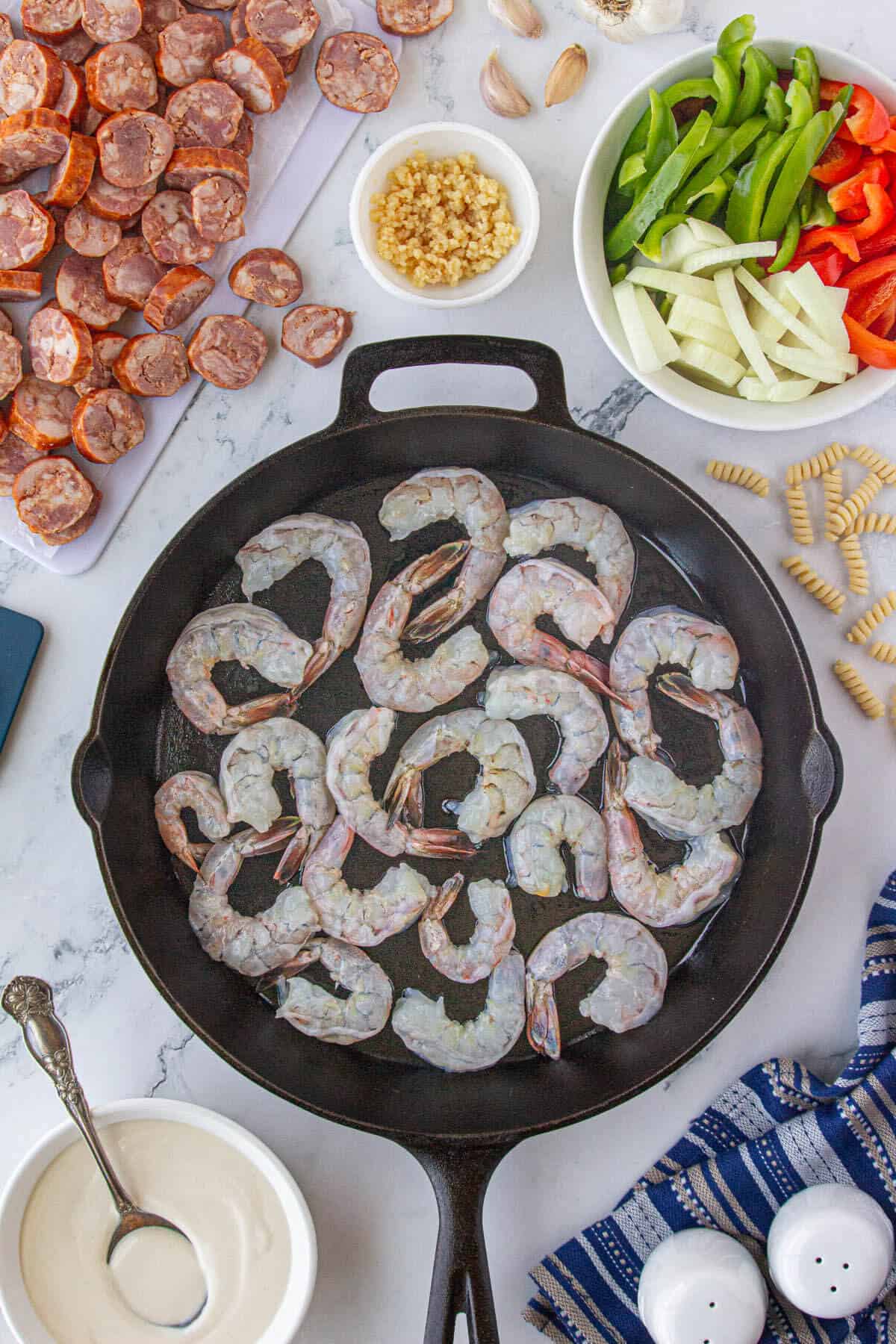 Shrimp sauteing in a cast iron skillet.