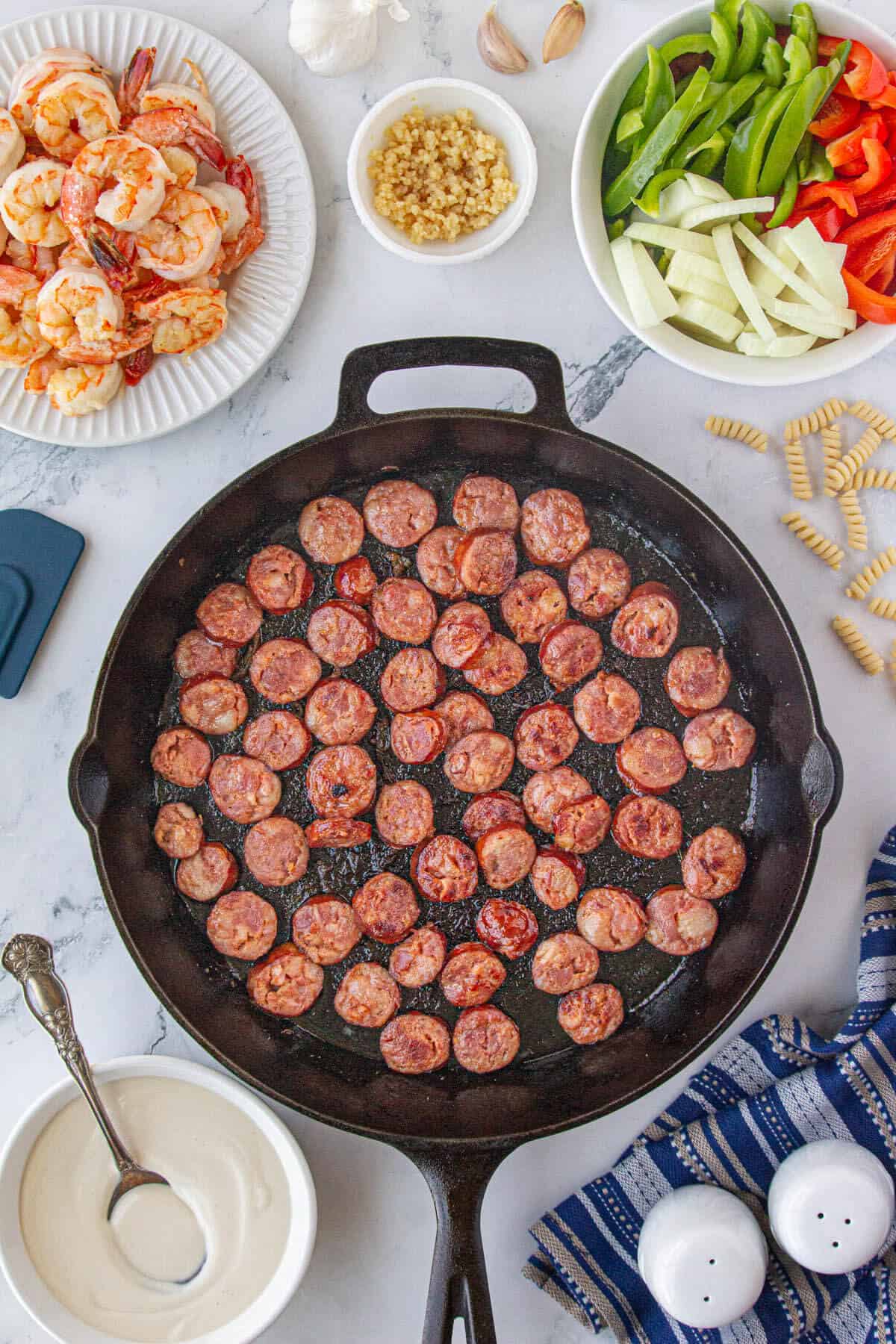 Sliced andouille sausage sauted in a skillet.