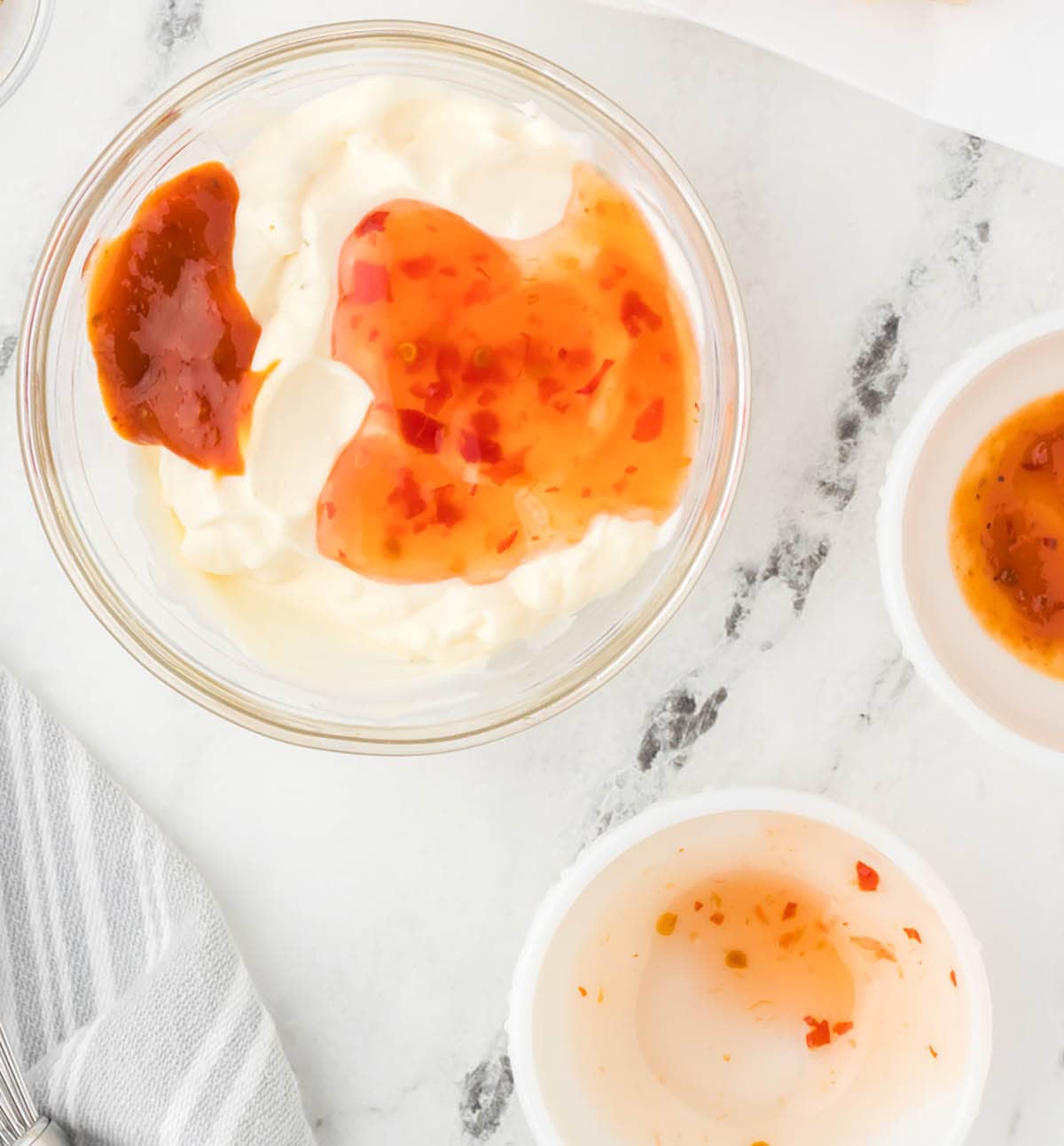 Ingredients for the bang bang sauce - mayonnaise, srirracha and chili sauce in a bowl.