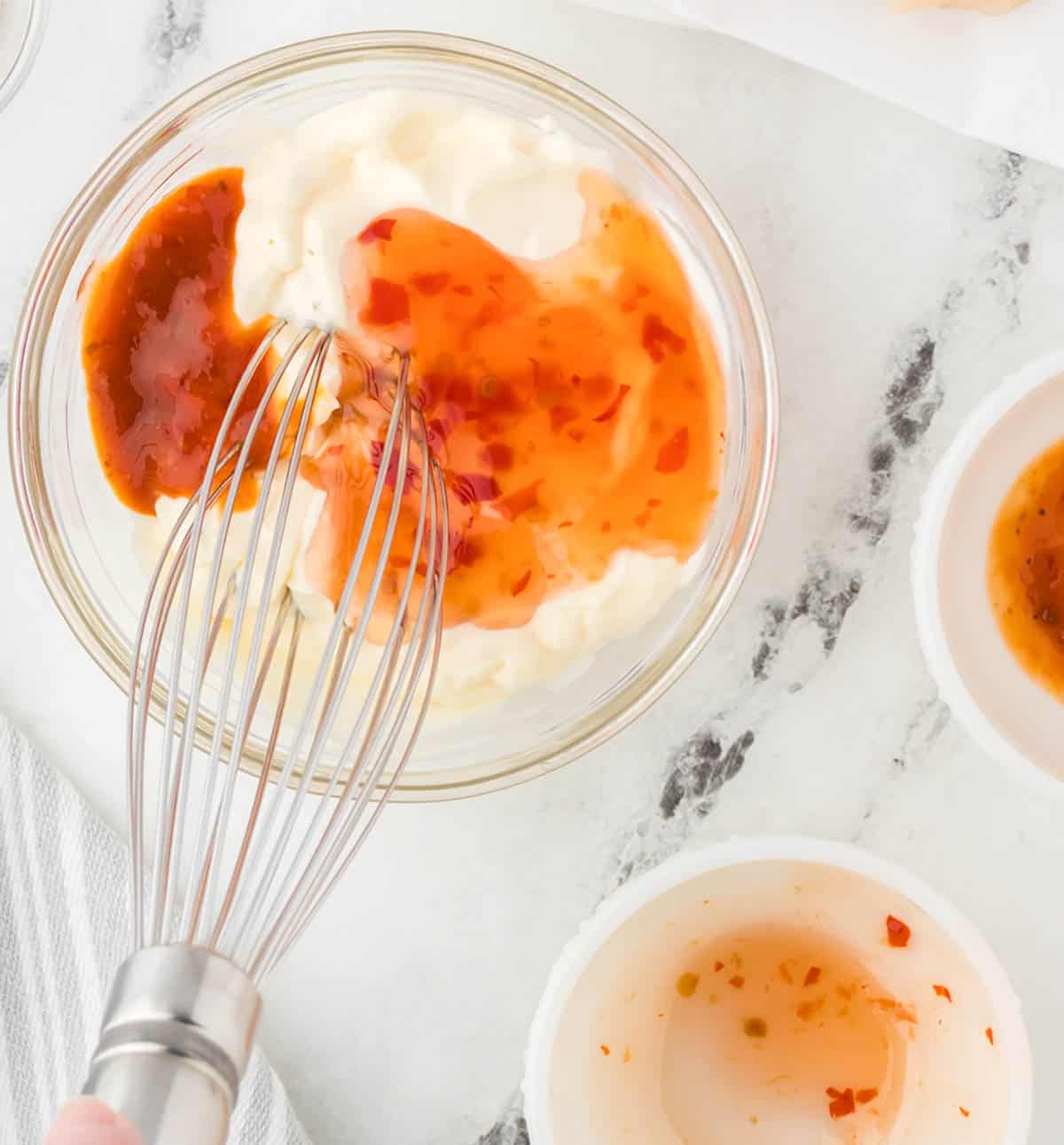 Whisking a creamy mayonnaise based sauce in a bowl.