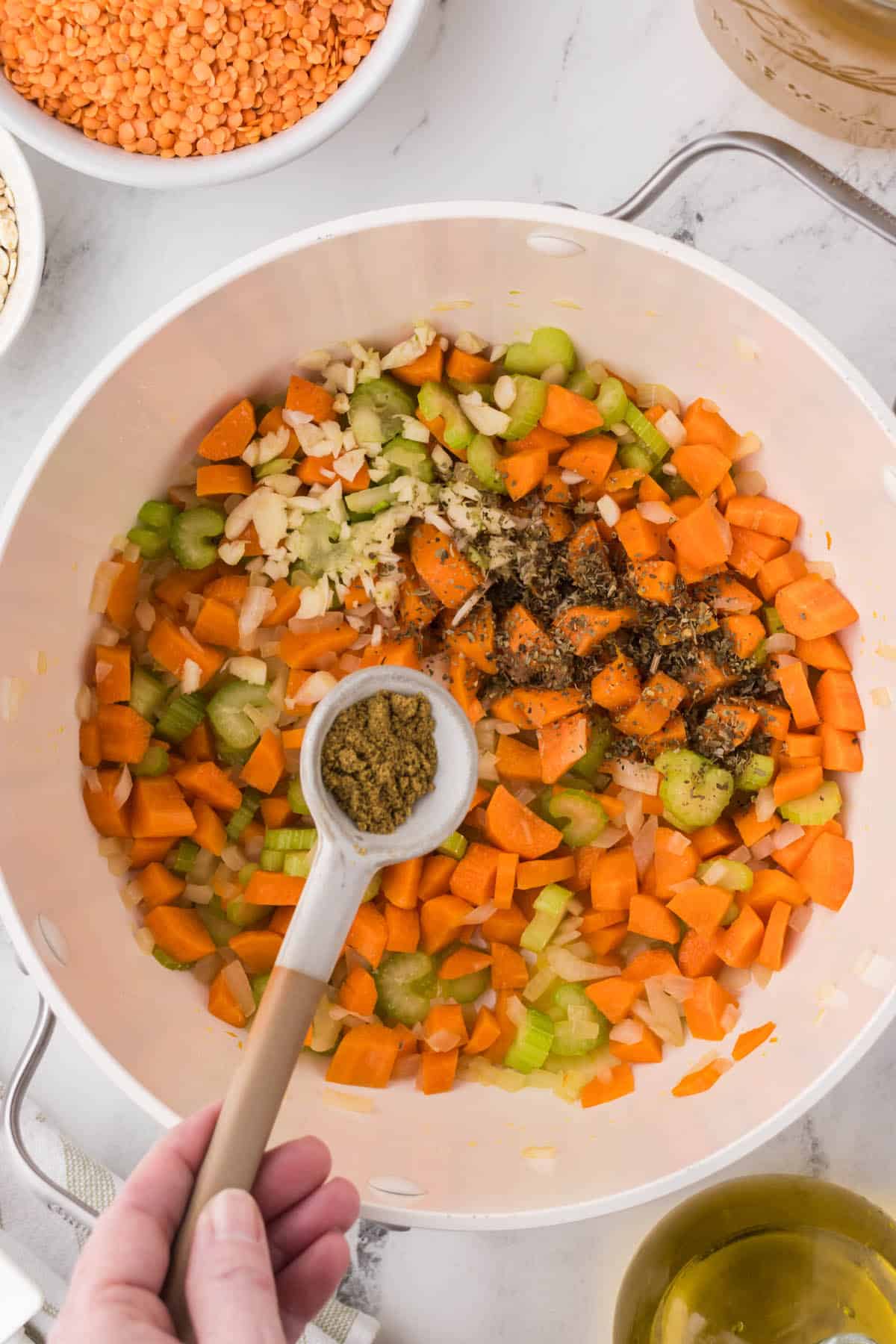 Seasoning added to a soup pot with ssautéed onions, carrots, celery and garlic.