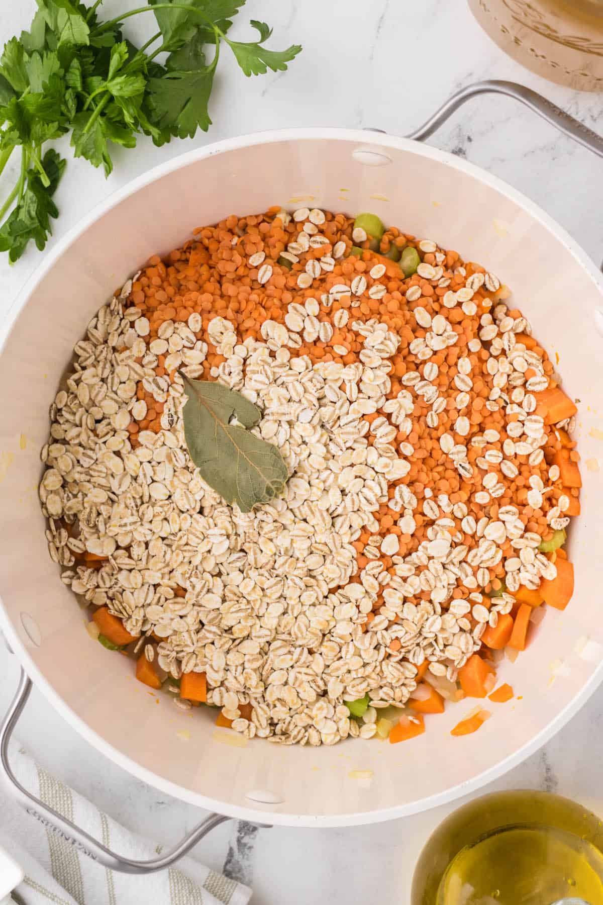 Red lentils, barley and a bay leaf in a large soup pot.