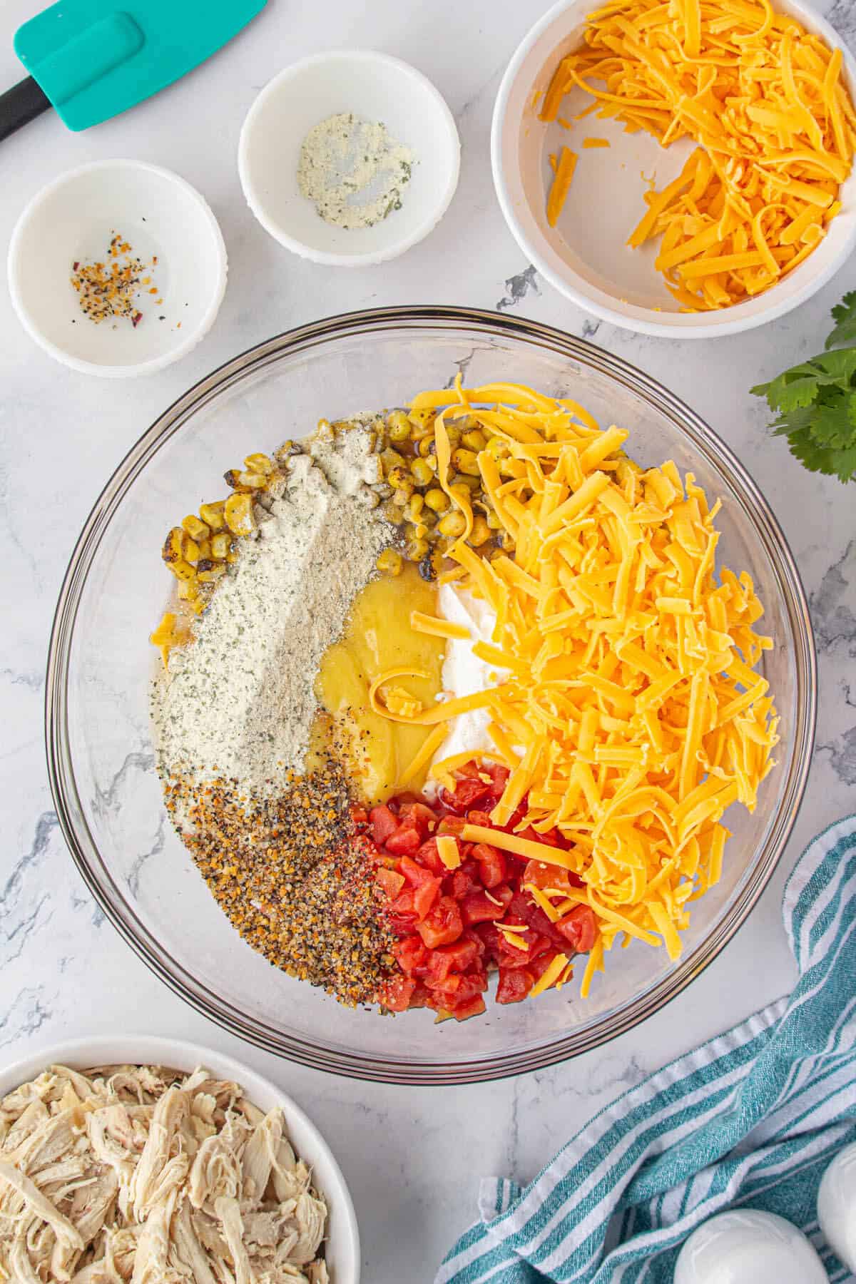 Seasoning added to the creamy base ingredients for a casserole in a large mixing bowl.