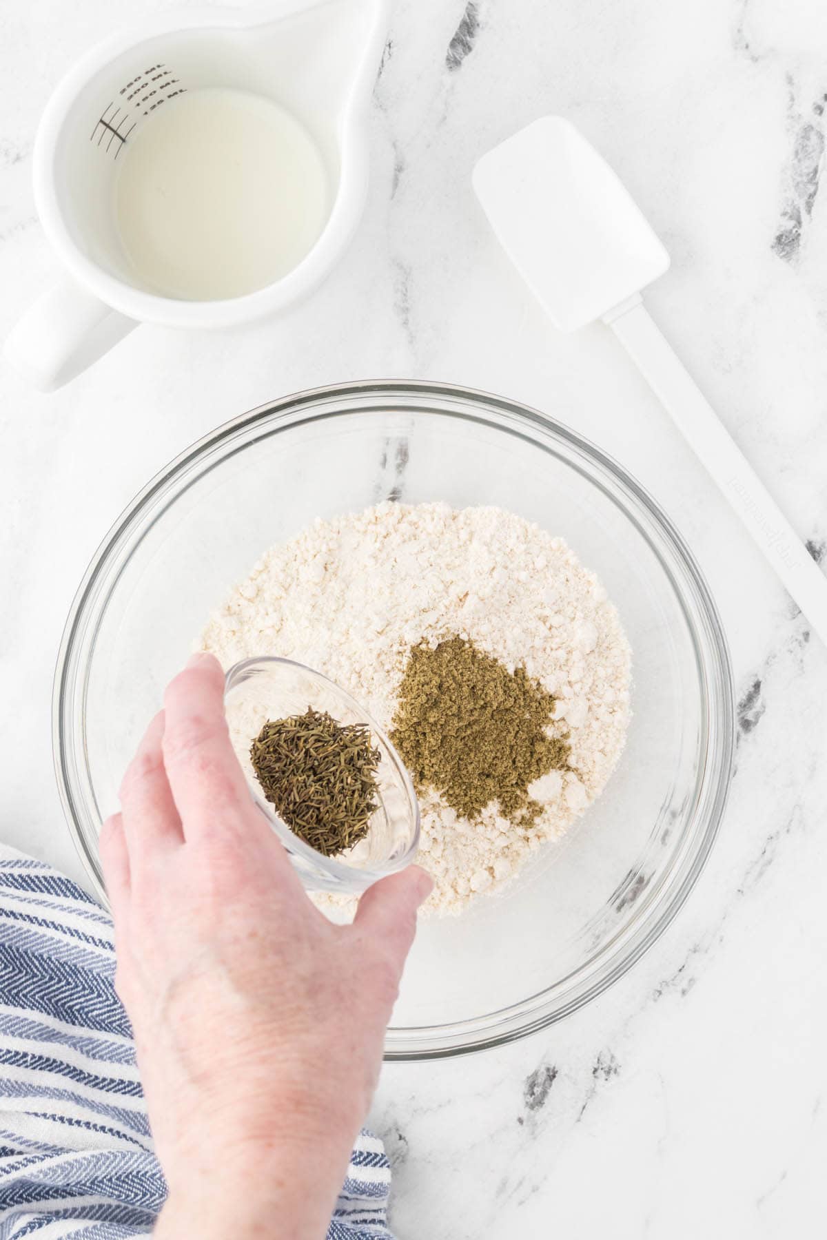 Seasoning added to a flour in a bowl.