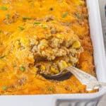 Corn Casserole in a baking dish, with a serving spoon taking out a spoonful.