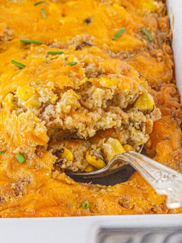 Corn Casserole in a baking dish, with a serving spoon taking out a spoonful.