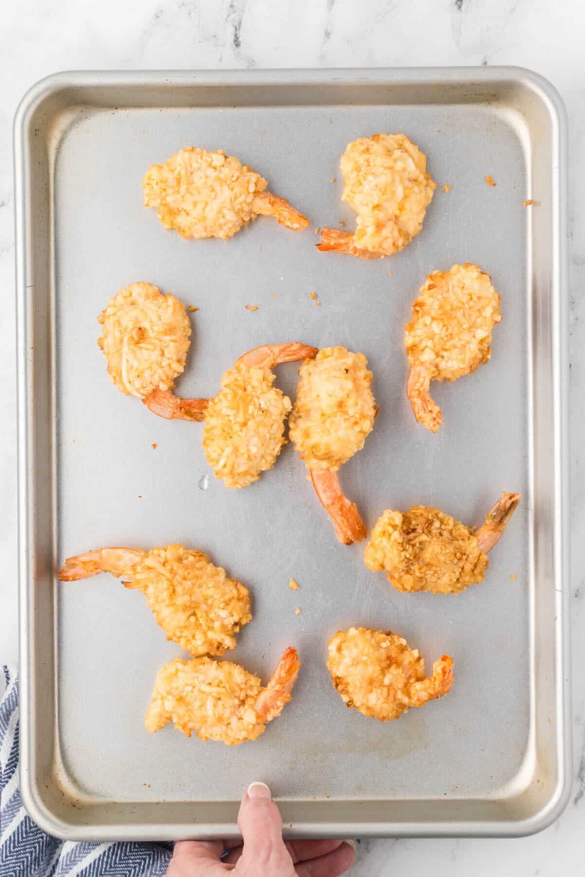 Baked coconut shrimp on a sheet pan.