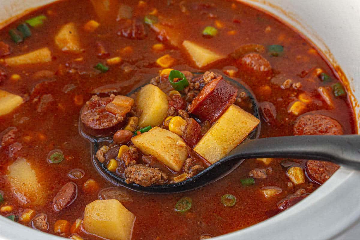 Soup in a crock pot with a ladle to dish up the stew.