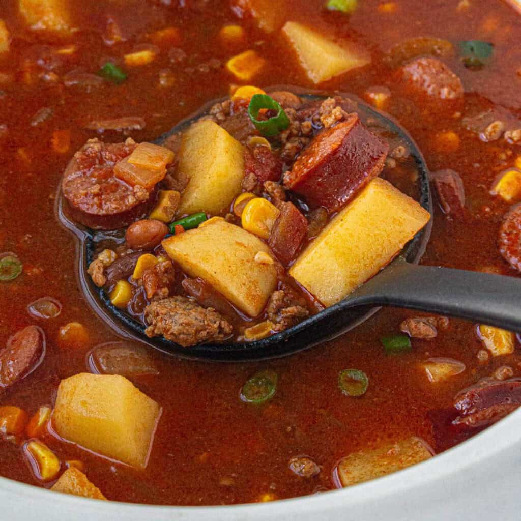 Cowboy stew in a crockpot with a ladle to dish up the soup.