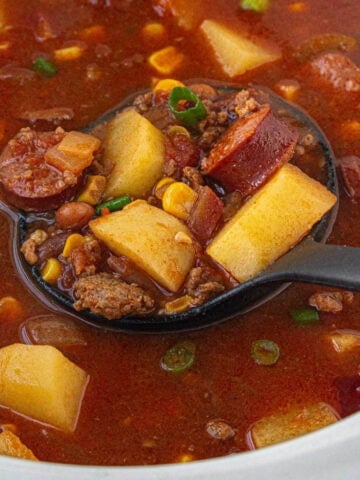 Cowboy stew in a crockpot with a ladle to dish up the soup.