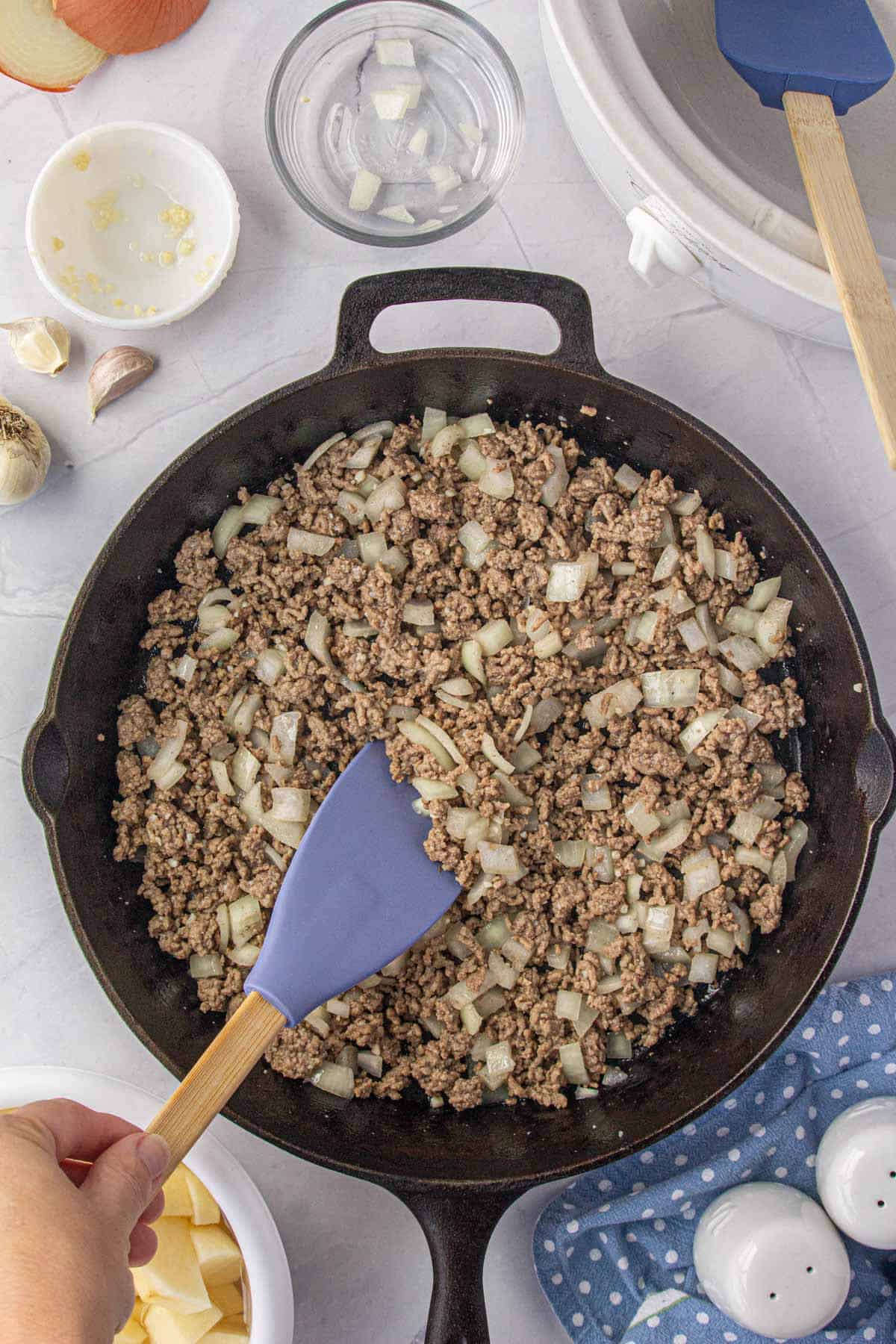 Ground beef and onions cooked in a cast iron skillet.