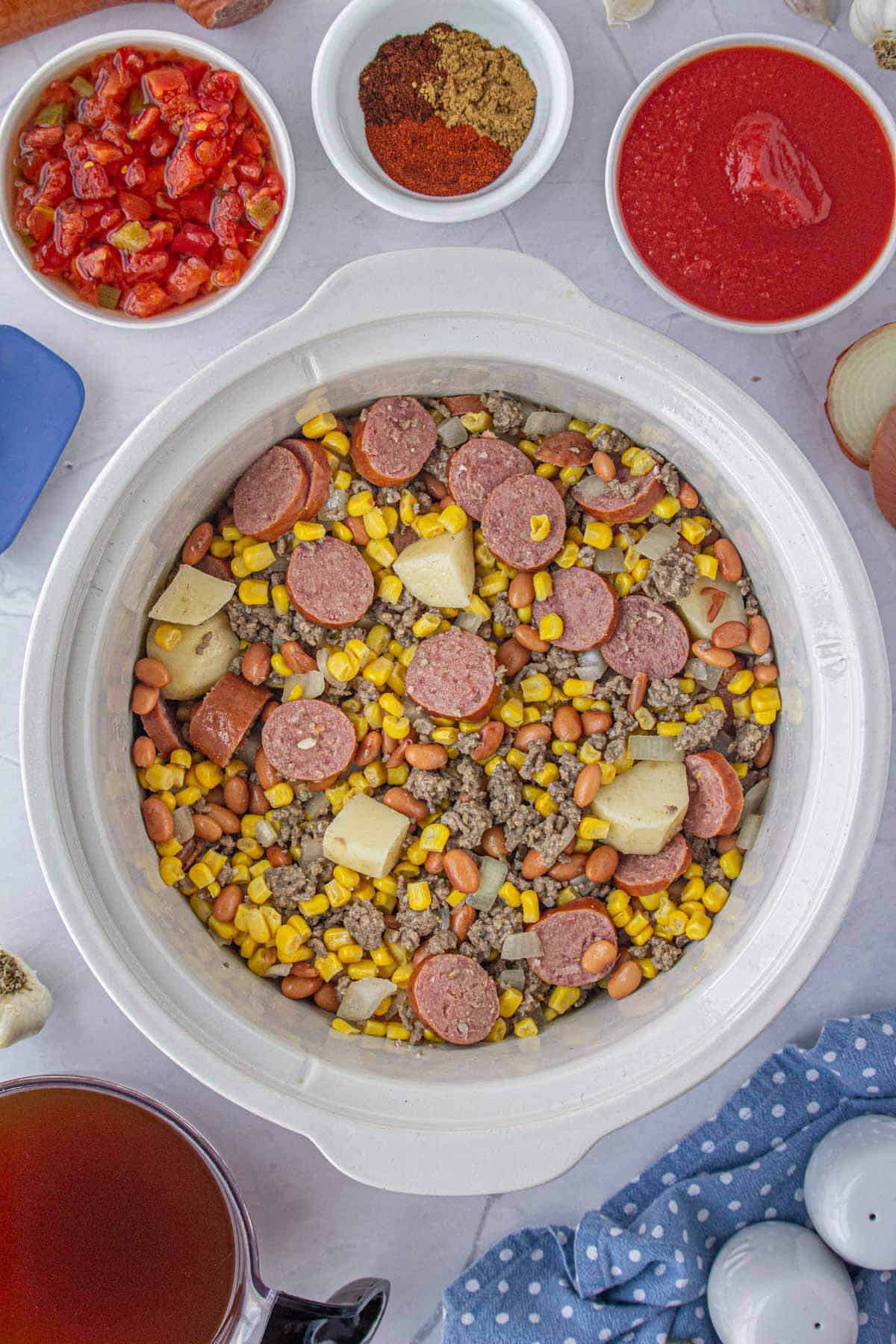 Soup ingredients in a white crockpot ready to cook.