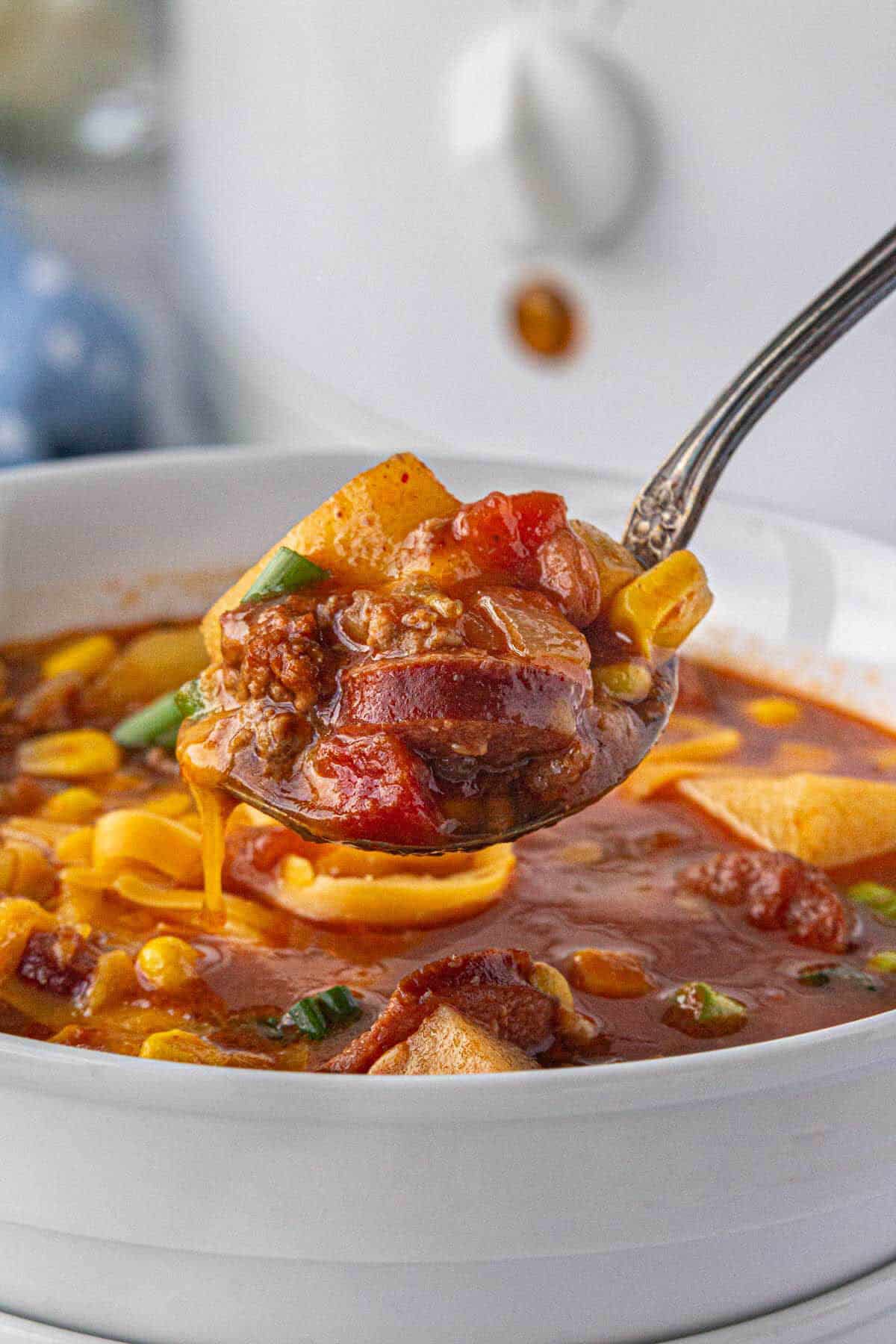 Bowl filled with a hearty soup, with a spoon scooping out a spoonful.