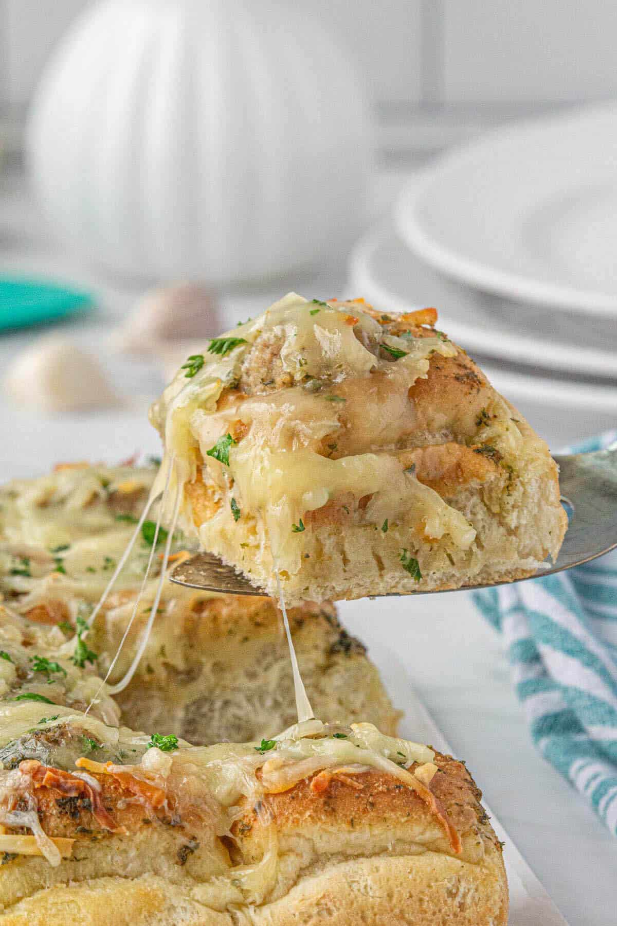 Baked Hawaiian meatball sliders being served on a spatula.