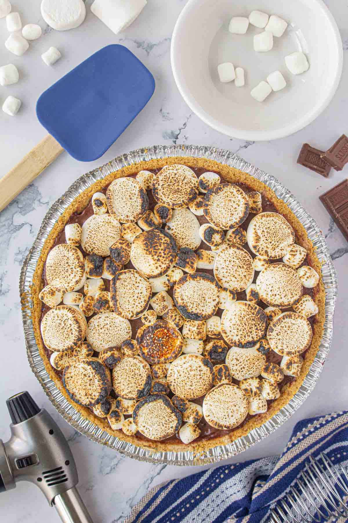 An overhead photo of s'mores pie on a graham cracker crust topped with toasted marshmallows.