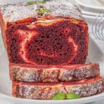 Red velvet loaf sliced on a platter.