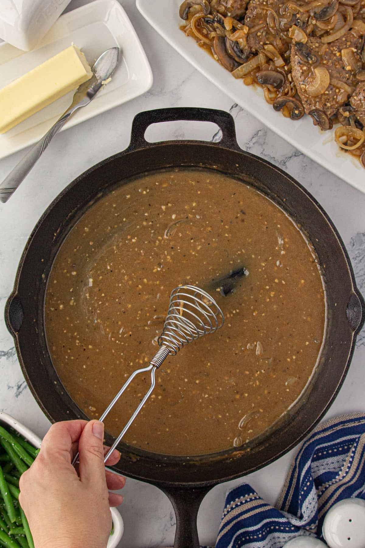 Gravy whisked in a cast iron skillet.