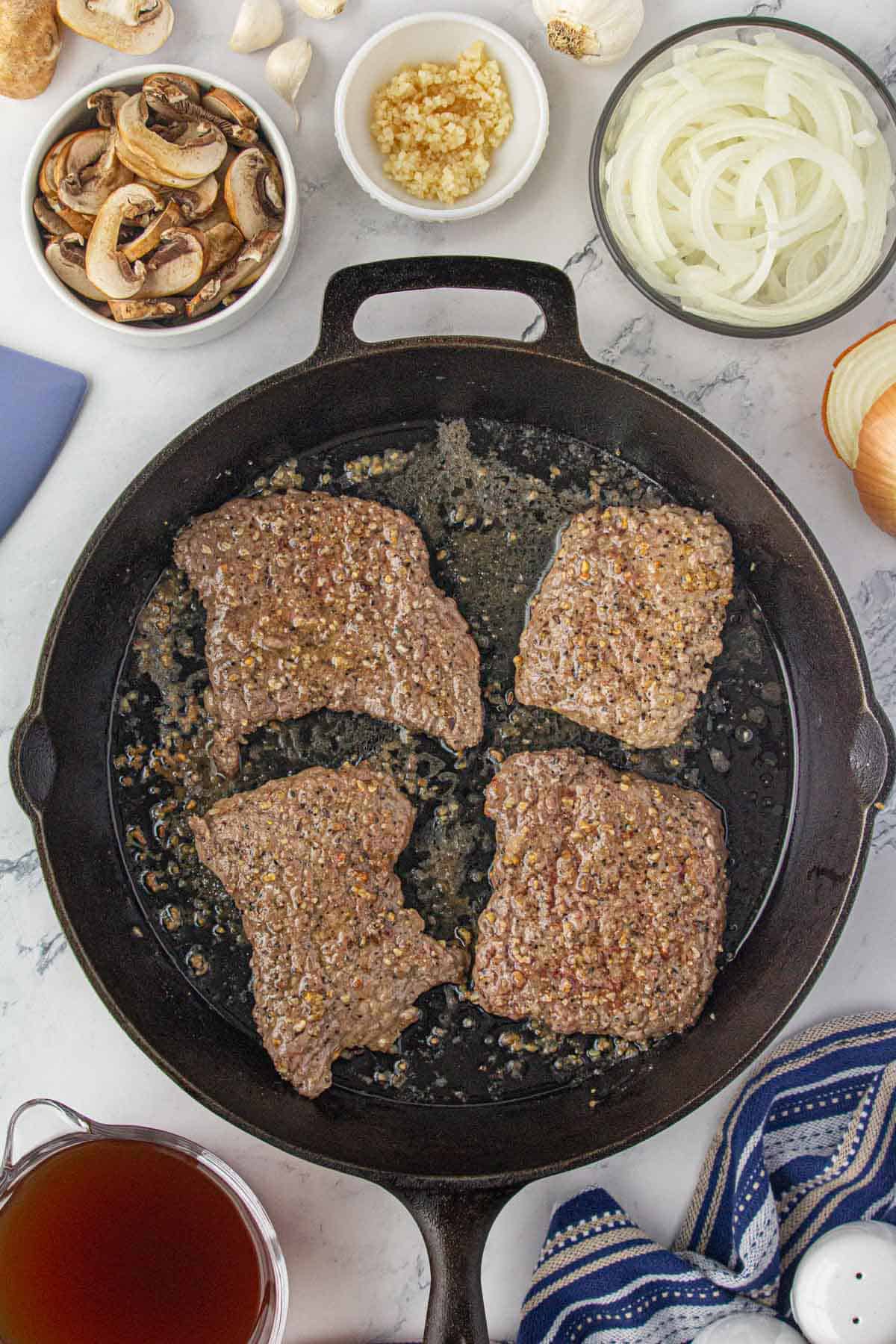 Browned steak in a skillet.