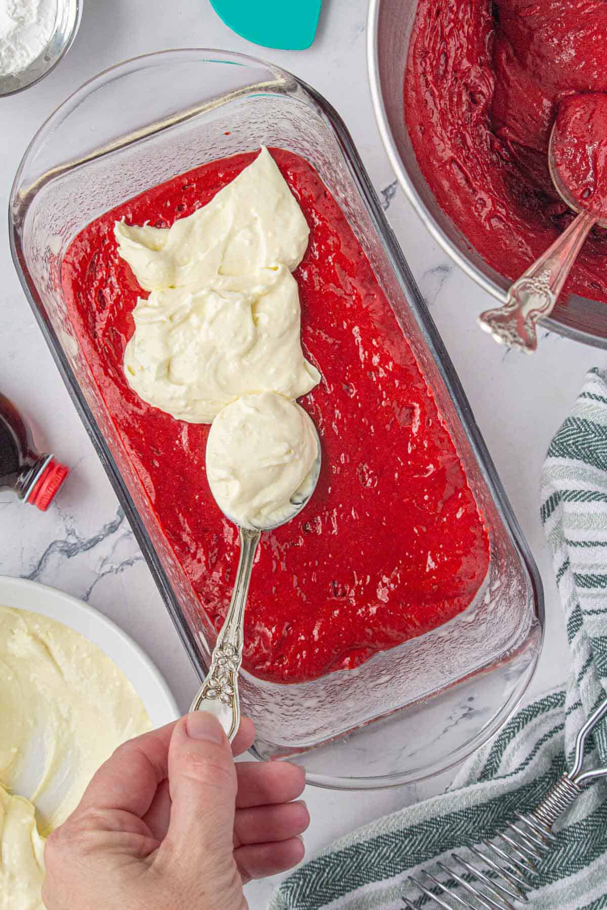 Batter in a loaf pan with a swirled white batter spooned on top.