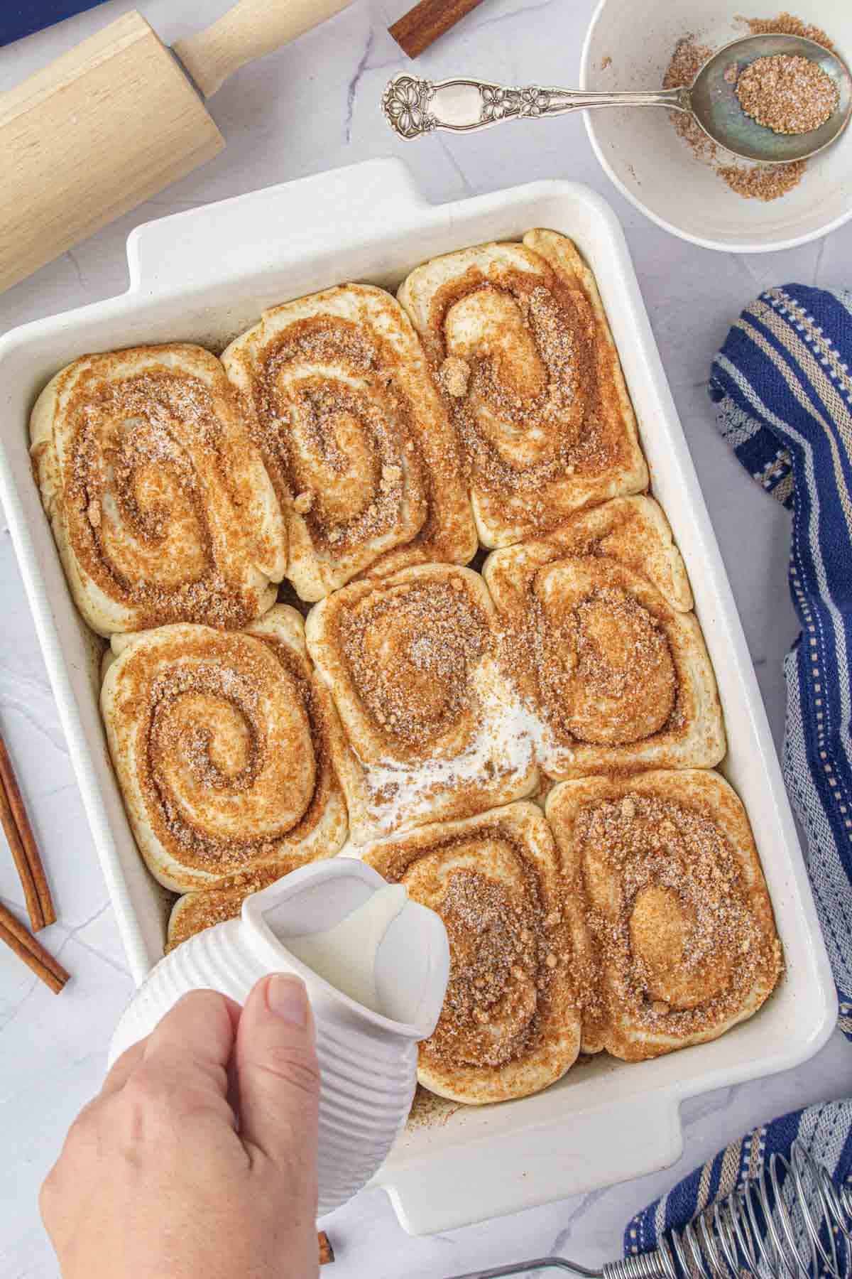 Heavy cream pour of cinnamon roll dough prior to baking.