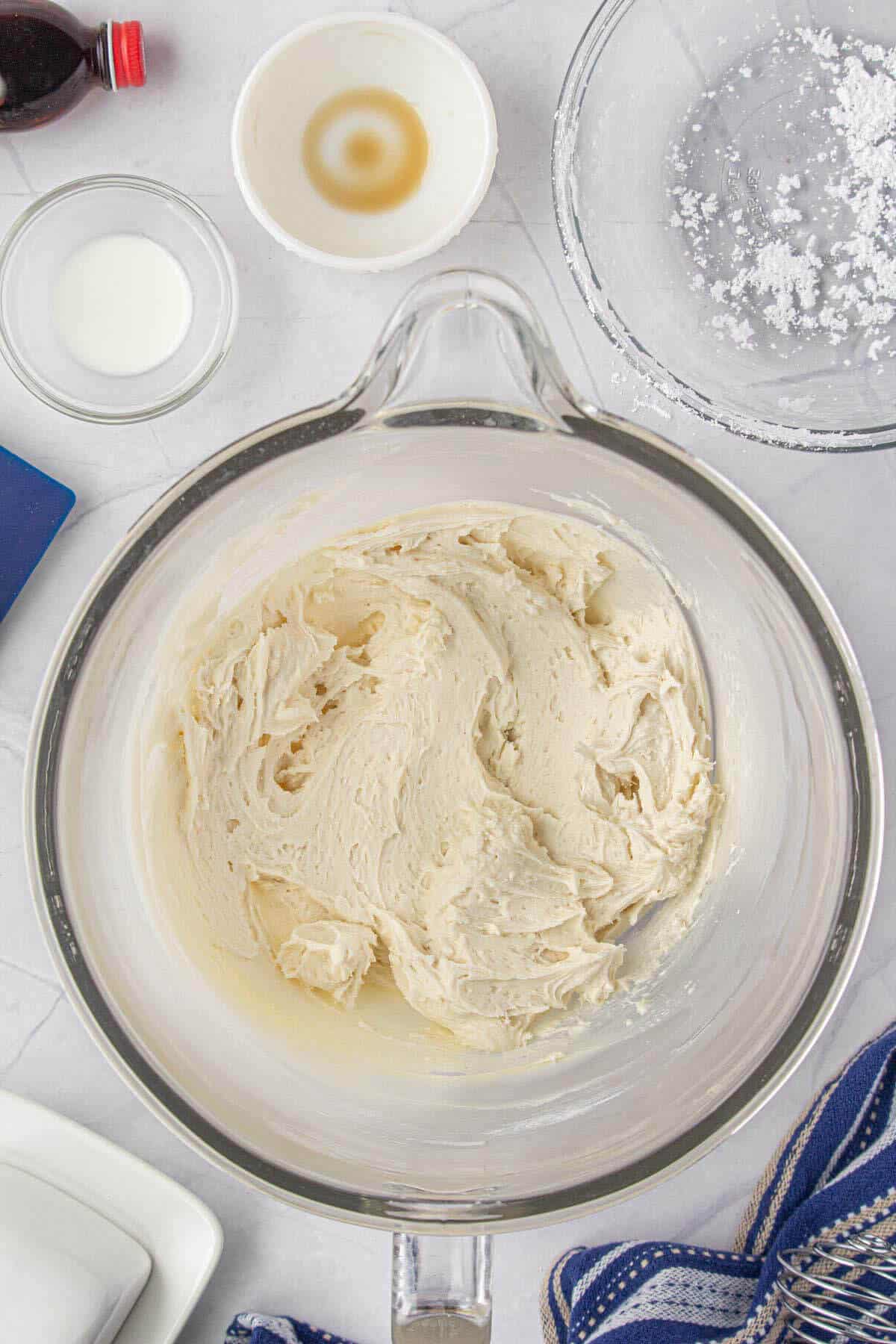 Creamy white frosting in a mixing bowl.