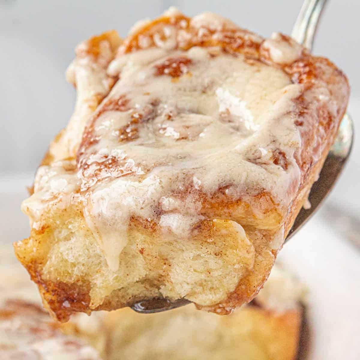 A fresh out of the oven cinnamon roll on a spatula that has been made with frozen bread dough.