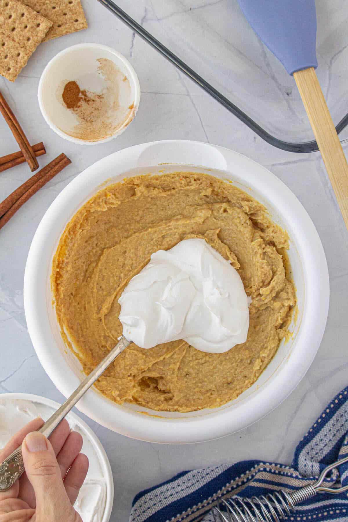 Vanilla cinnamon pudding being mixed with cool whip.