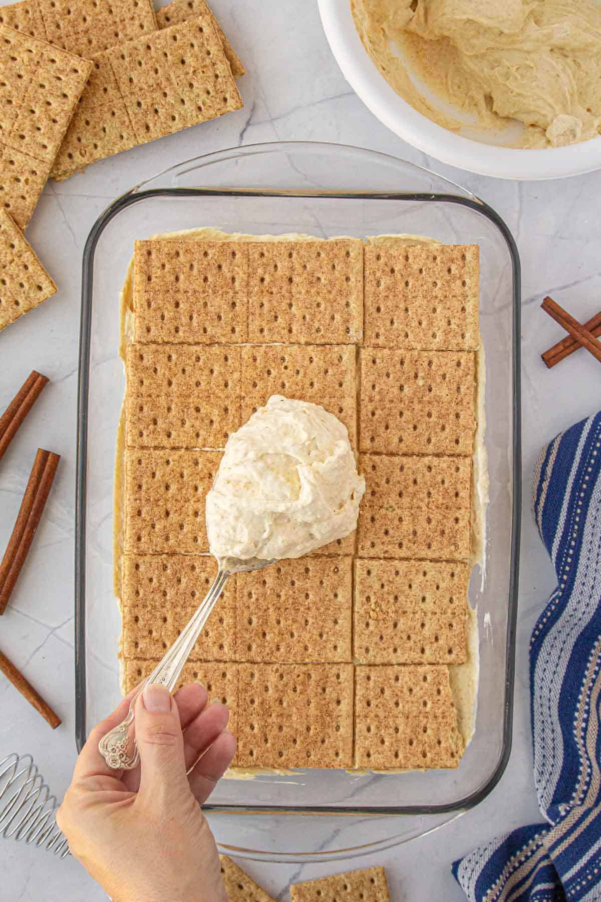 Pudding being spread over the top of a layer of graham crackers to make the icebox pie.