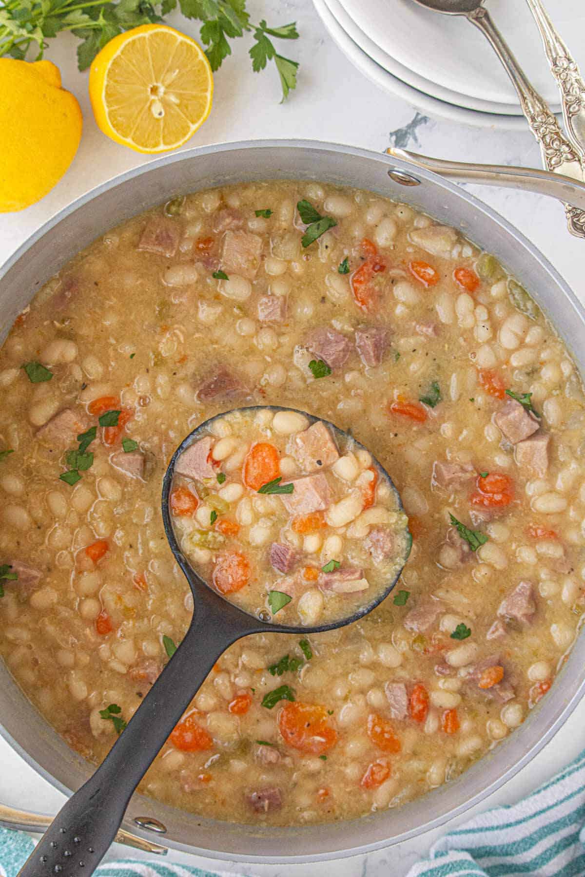 Navy bean soup in a pot with a ladle.