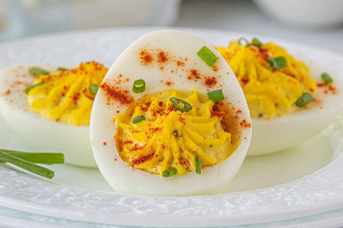 Three deviled eggs on a small white plate.