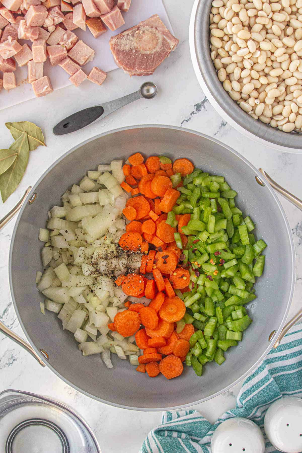 Seasoning in a pot with onions, celery and carrots in a soup pot.