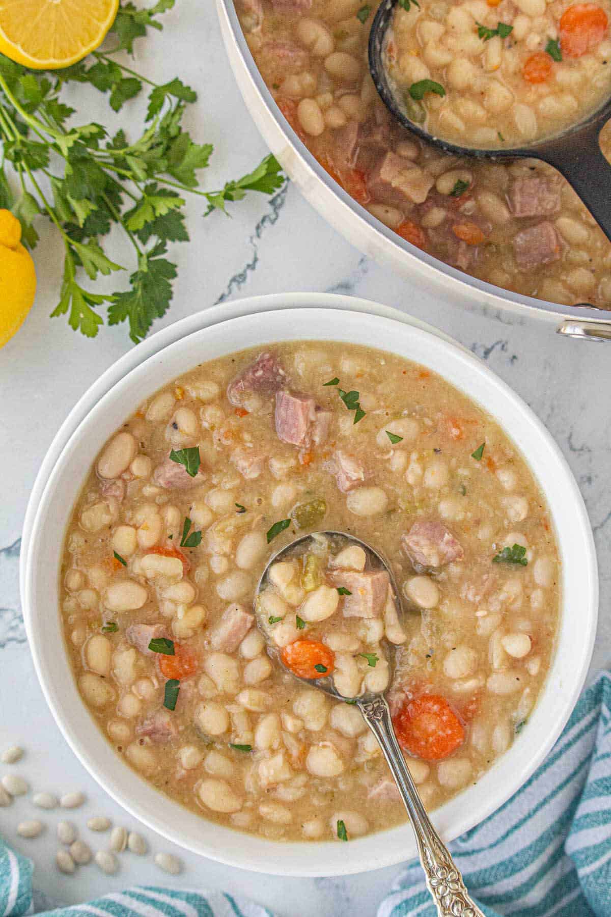 A white bowl filled with soup, with a spoon.