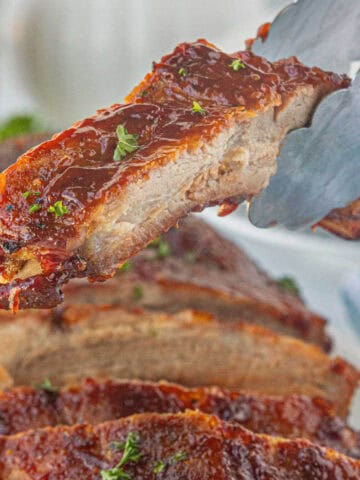 BBQ pork ribs sliced and slathered with sauce.